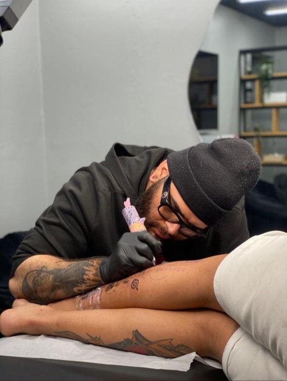 Tatuador realizando microrealismo en Flizart Tattoo Santiago.